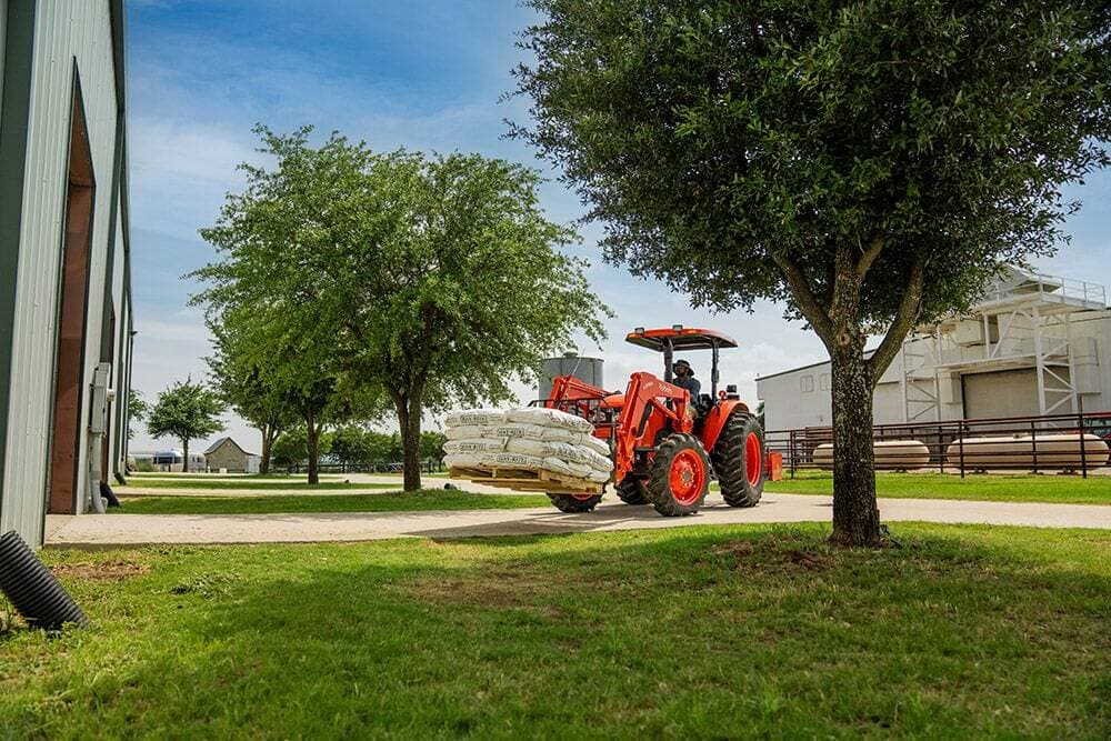 Man using tractor to move heavy material